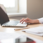 Woman sitting at desk working on laptop.